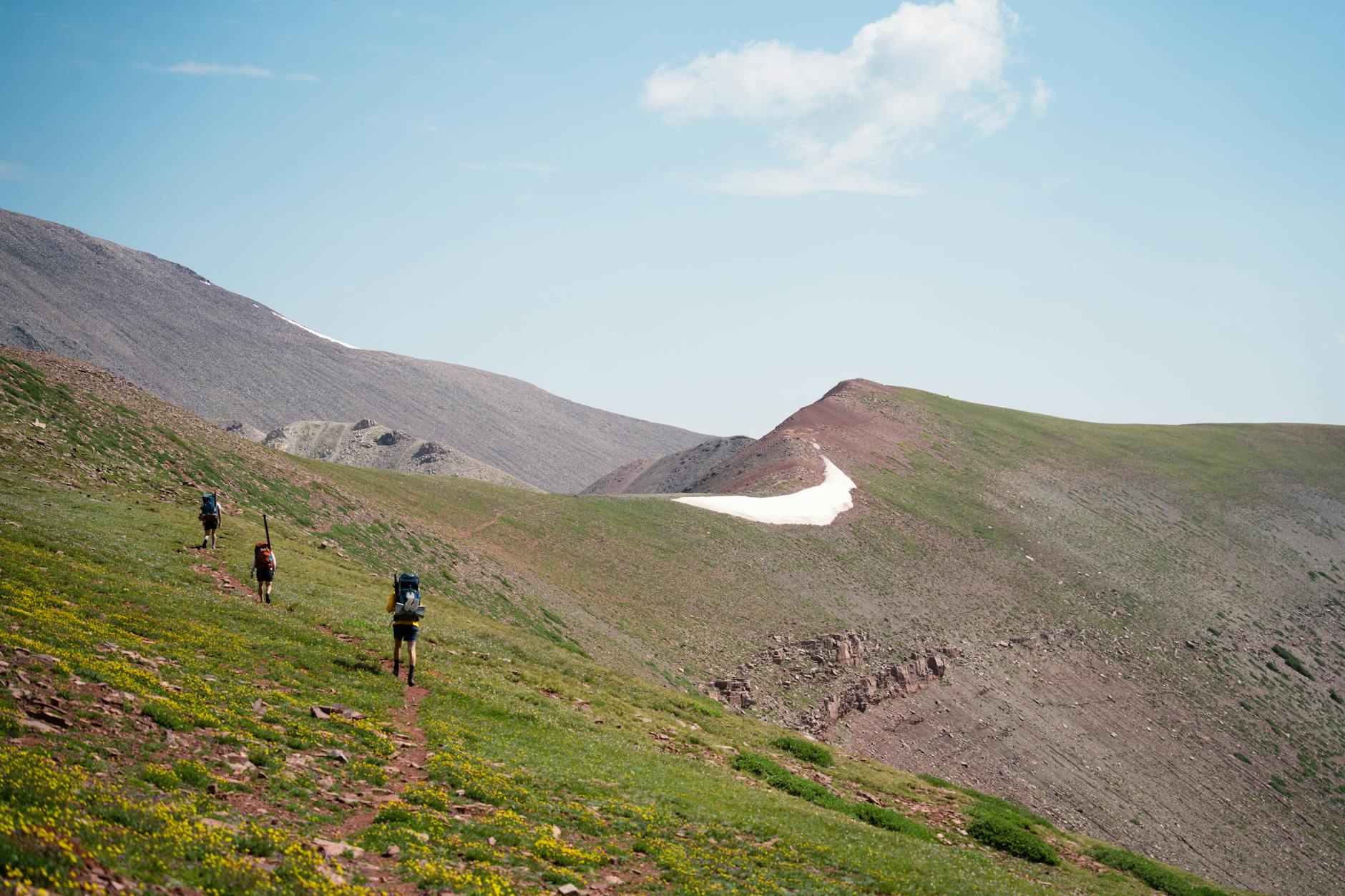 Turyści na letnim szlaku górskim pod błękitnym niebem